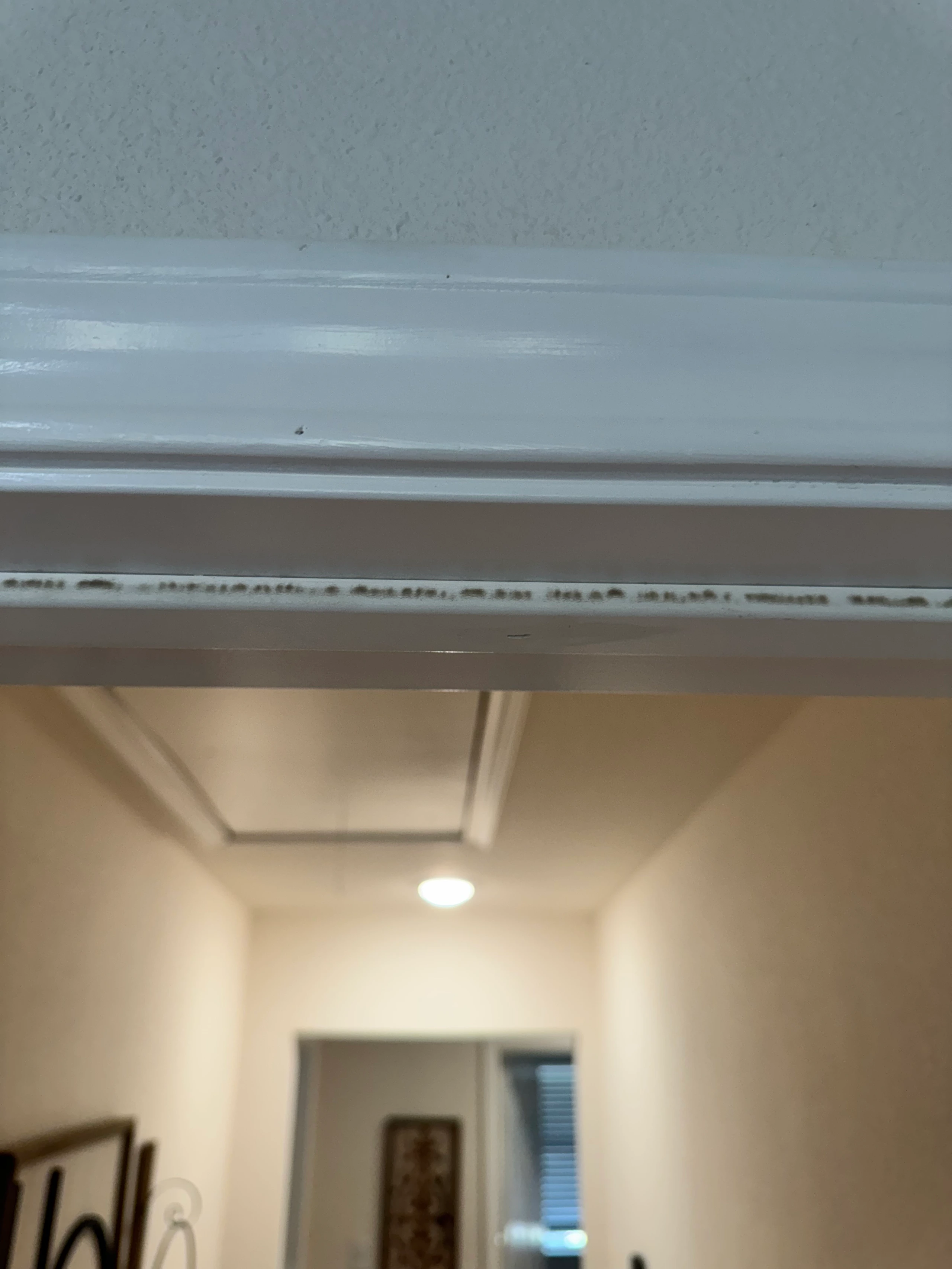 Black mold spotting on doorframe trim in Airbnb that homeowners often dismiss as harmless mildew